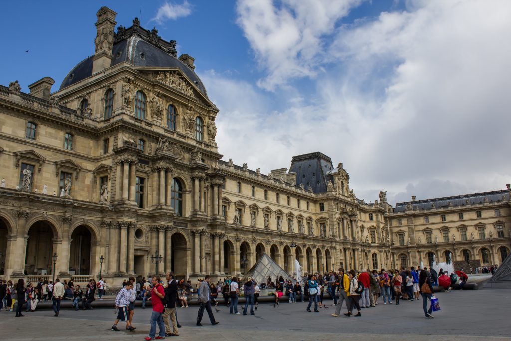 Turistas frente al Louvre cerrado por protesta laboral, símbolo del impacto del turismo masivo.