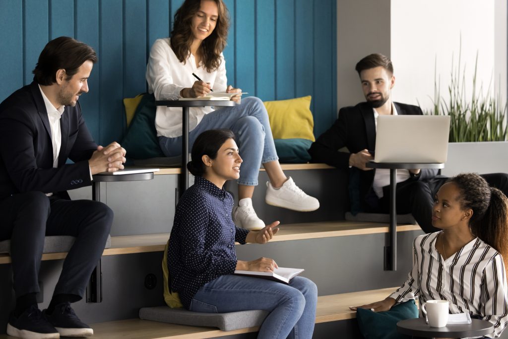 Estudiantes internacionales colaborando en un aula moderna con banderas de distintos países, símbolo de competencias interculturales