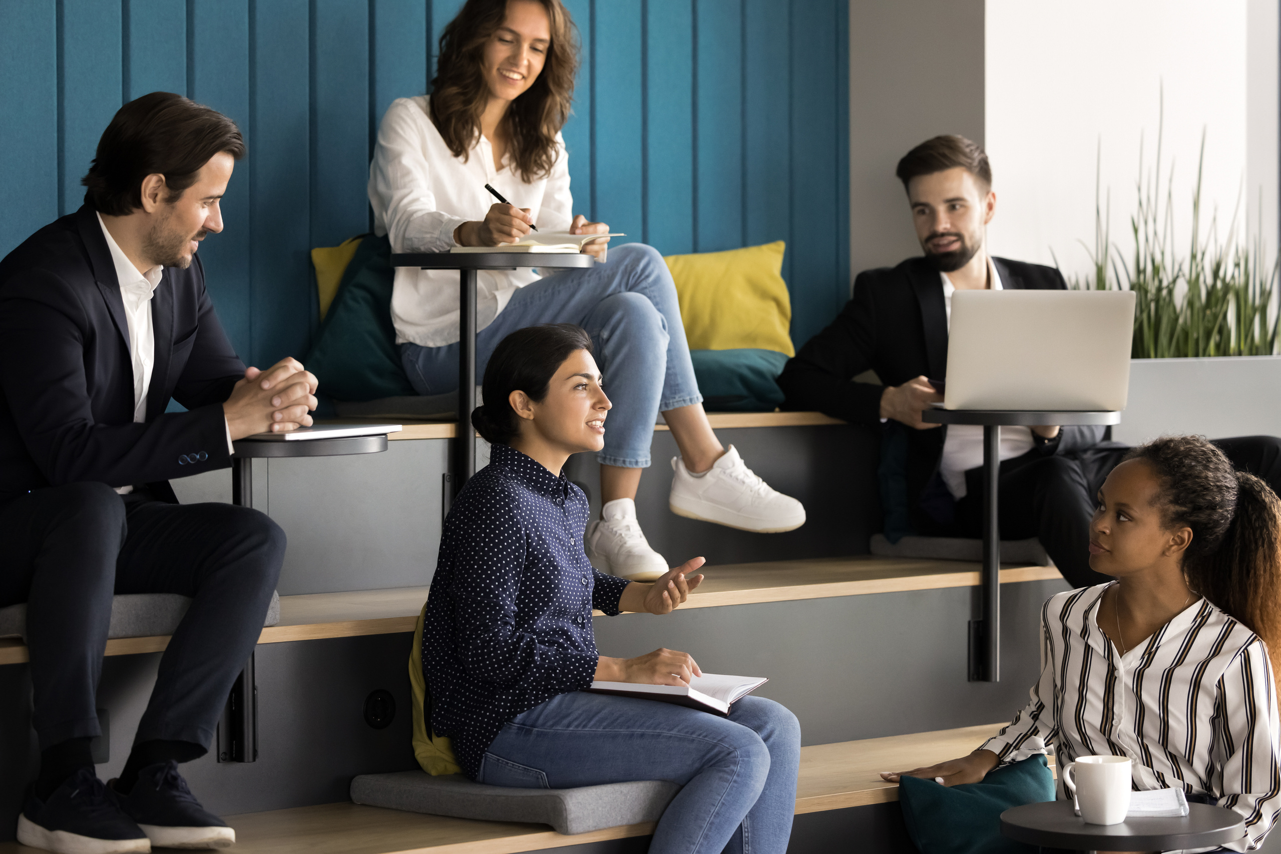 Estudiantes internacionales colaborando en un aula moderna con banderas de distintos países, símbolo de competencias interculturales