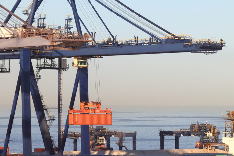 Puerto marítimo en México con contenedores y grúas, representando el impacto de la reforma arancelaria en importaciones y comercio.