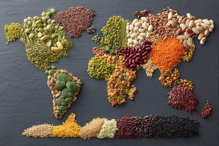 Mapa del mundo en una celebración del Día Mundial de la Alimentación, con semillas y verduras frescas.