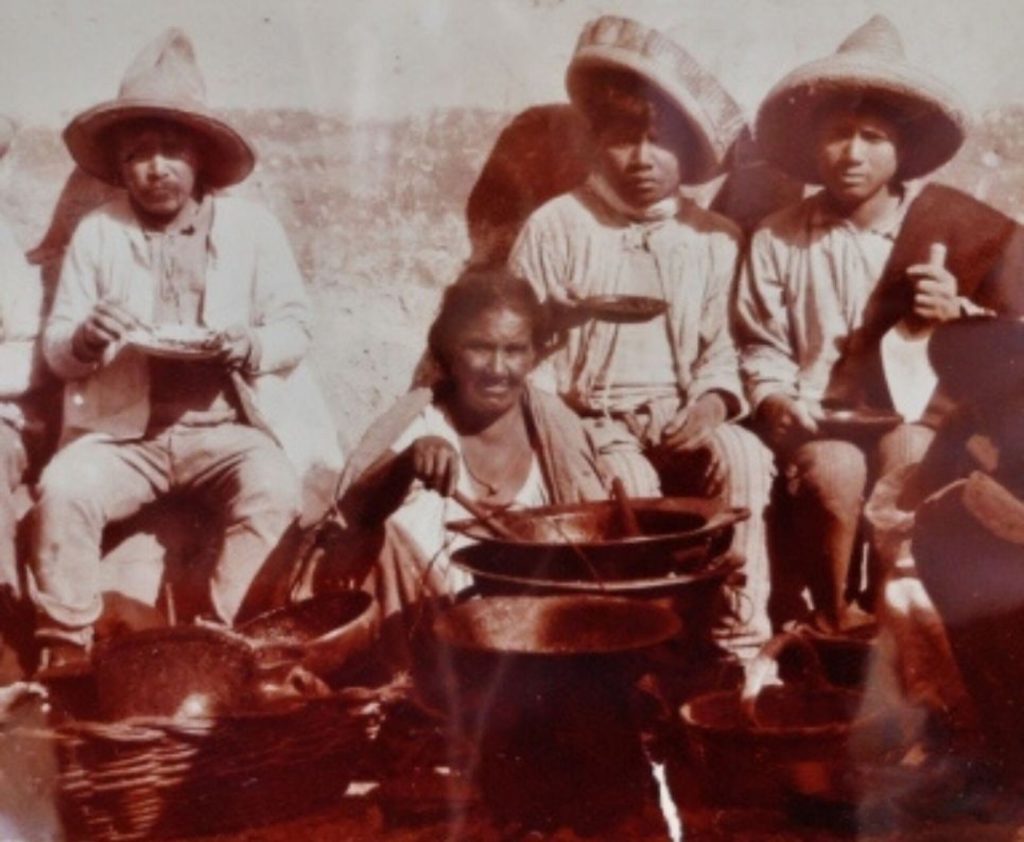 Soldadera mexicana preparando comida durante la Revolución, símbolo de la alimentación del pueblo y la identidad nacional.