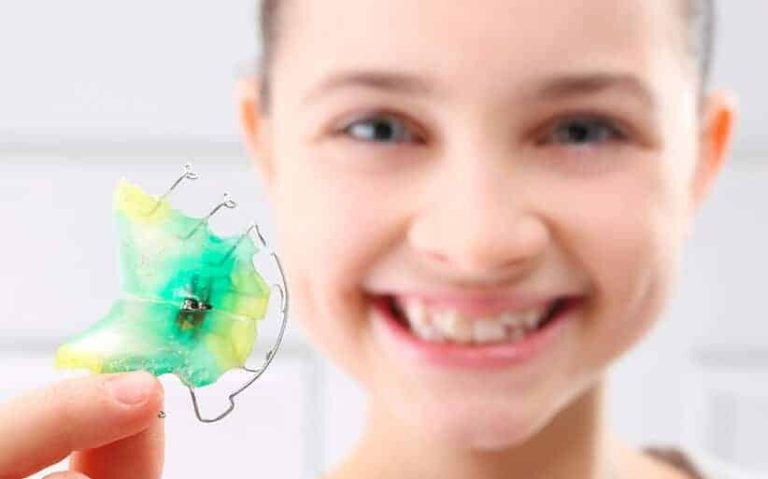 Niña utilizando aparatología ortopédica dental para corregir el crecimiento facial en tratamiento de ortopedia maxilar.