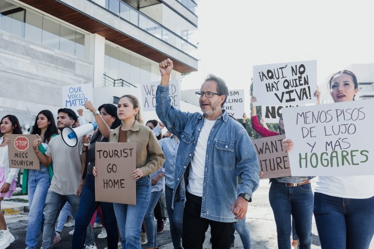 Personas protestando contra la gentrificación en un barrio urbano.