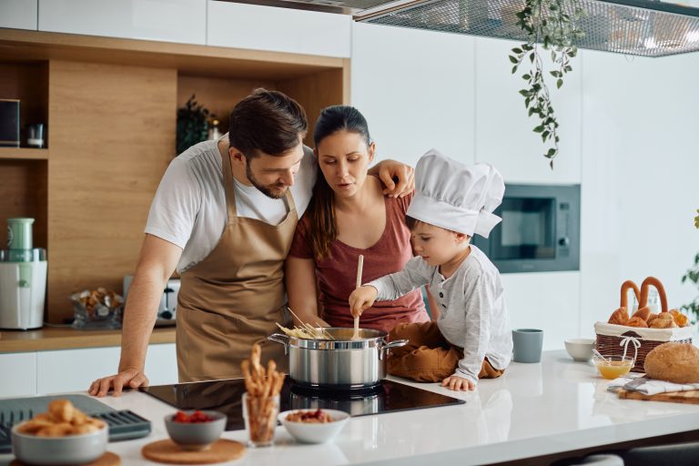 Niño preparando alimentos con sus papás como parte de hábitos de nutrición infantil