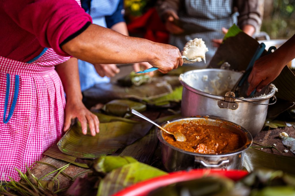 Mesa compartida con platillos de distintas culturas, símbolo de alimentación y construcción de paz