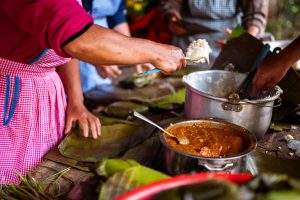 Mesa compartida con platillos de distintas culturas, símbolo de alimentación y construcción de paz