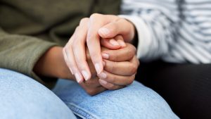 Manos que se sostienen suavemente, metáfora de la necesidad de ser necesario en una relación