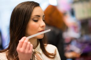 Mujer oliendo un perfume gracias al marketing