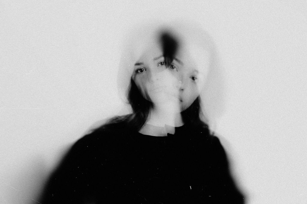 Mujer cuyo reflejo se ve duplicado, imagen que ilustra el trastorno de identidad disociativo