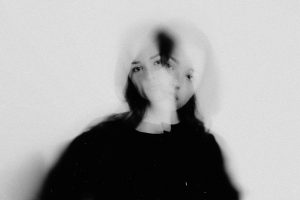 Mujer cuyo reflejo se ve duplicado, imagen que ilustra el trastorno de identidad disociativo
